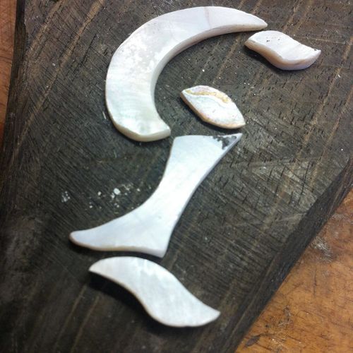 Capital letters - mother of pearl hand cutted pieces before carving and gluing